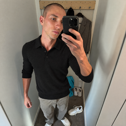Mirror photo of the black Bleamme Long Sleeve Knit Polo with chinos and white sneakers